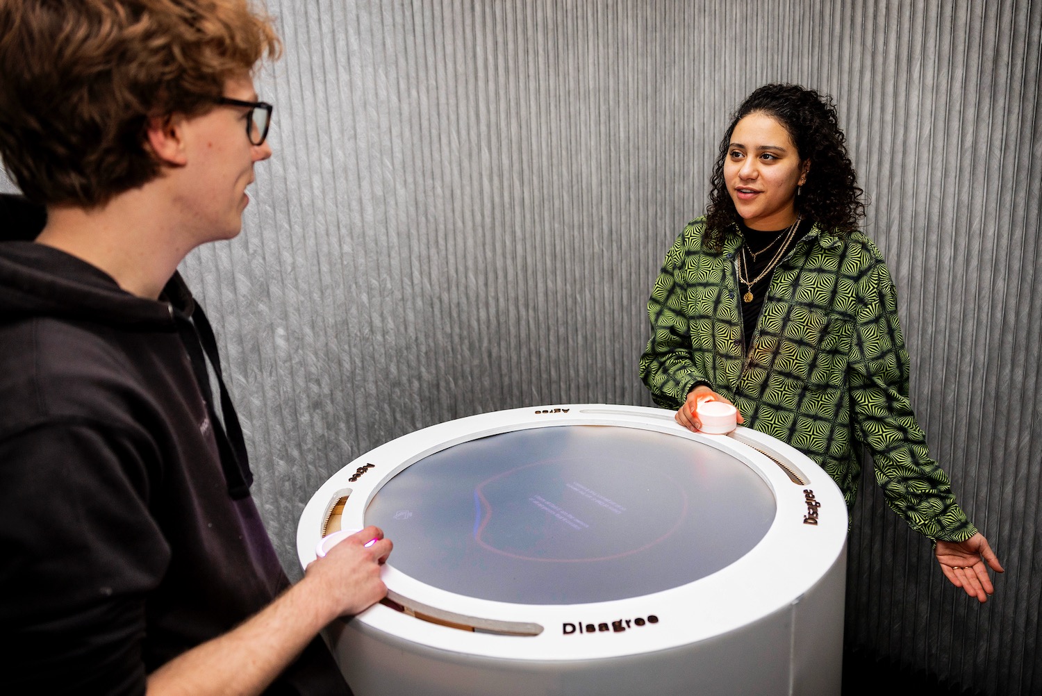 People discussing a complex topic facilitated by the interactive installation called Claudia